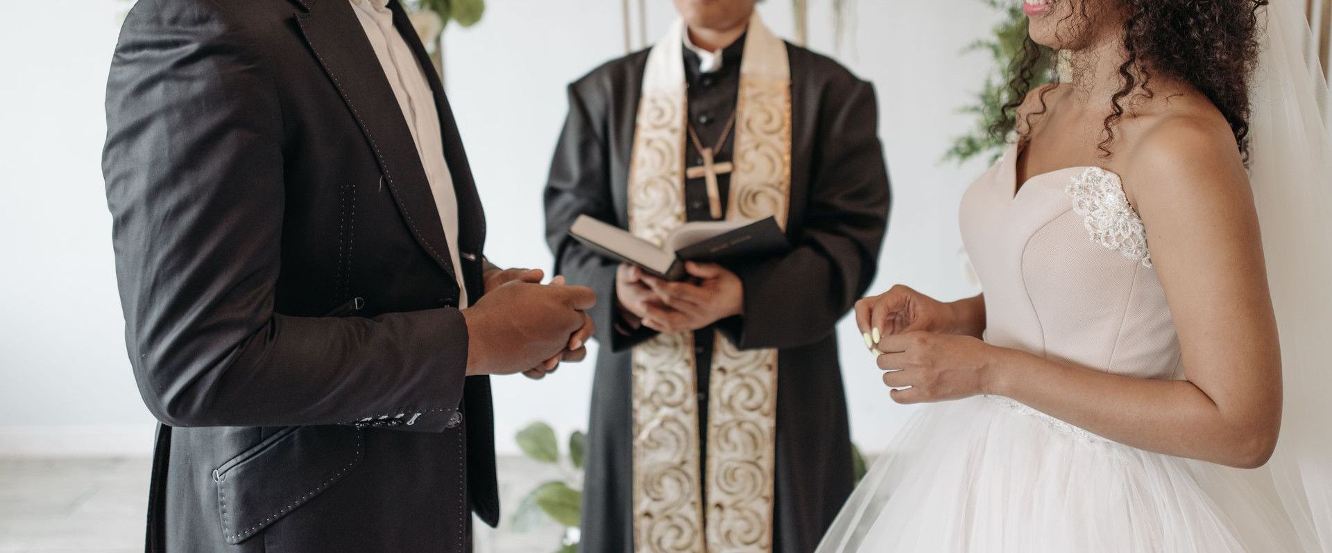 A beautiful wedding ceremony with a diverse couple exchanging vows indoors.
