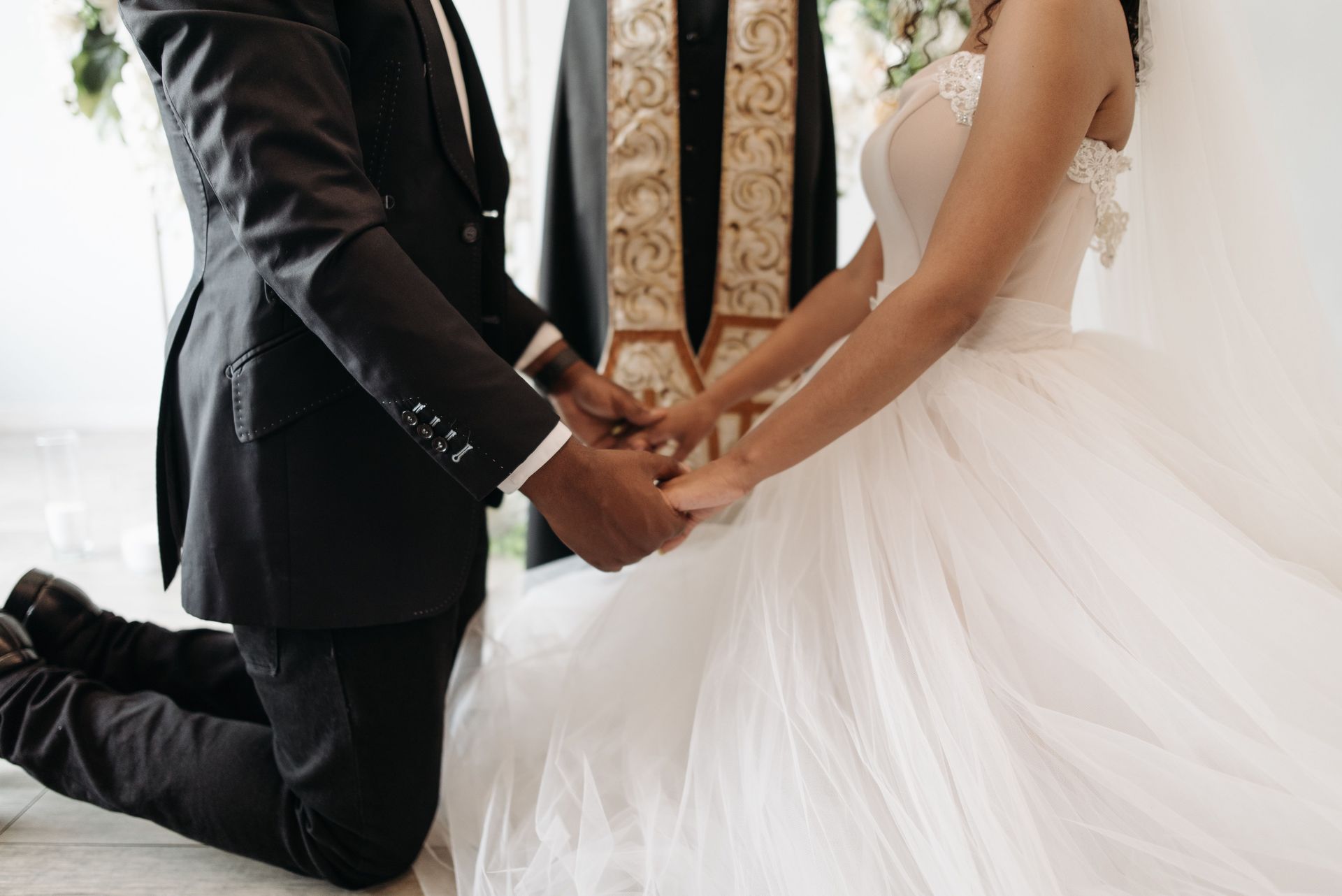 Beautiful wedding ceremony with couple holding hands in formal attire.